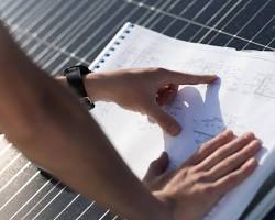 Técnico a analisar plantas de uma instalação elétrica.
